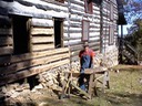 A master craftsman just having finished hand hewning logs.